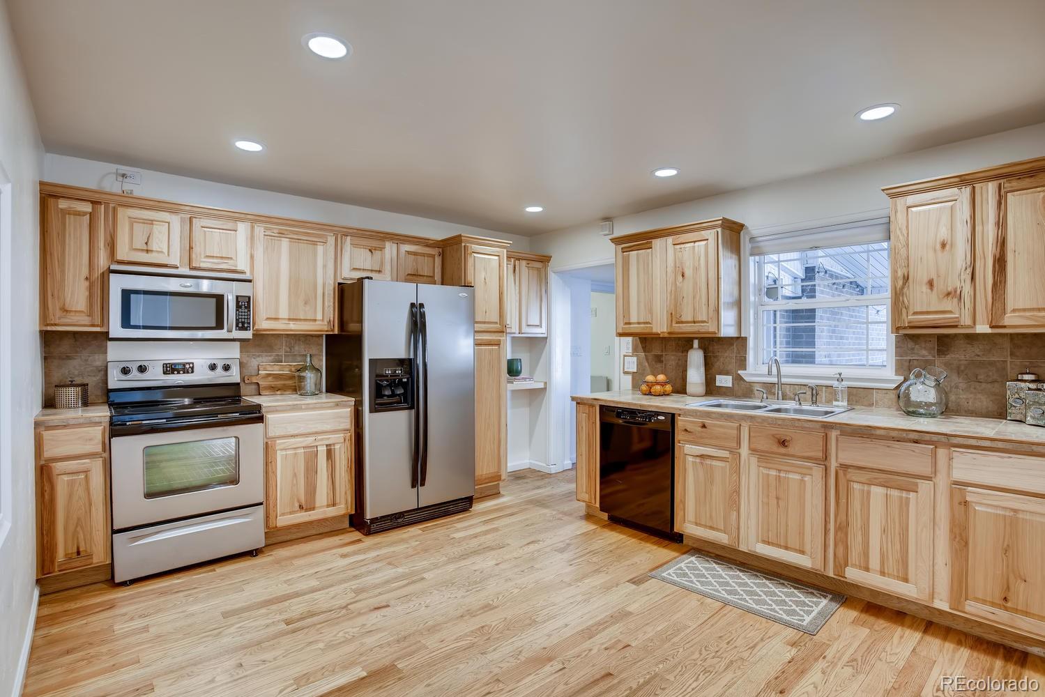 1718 South Decatur Street Denver, CO 80219 - Photo 10 of 28 a kitchen with stainless steel appliances granite countertop a refrigerator stove microwave and sink