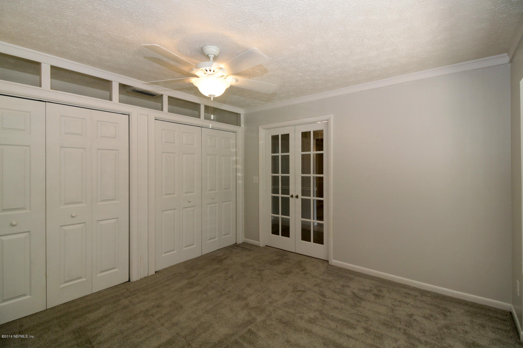 2015 Cornell Road Middleburg, FL 32068 - Photo 21 of 42 an empty room with windows and chandelier fan