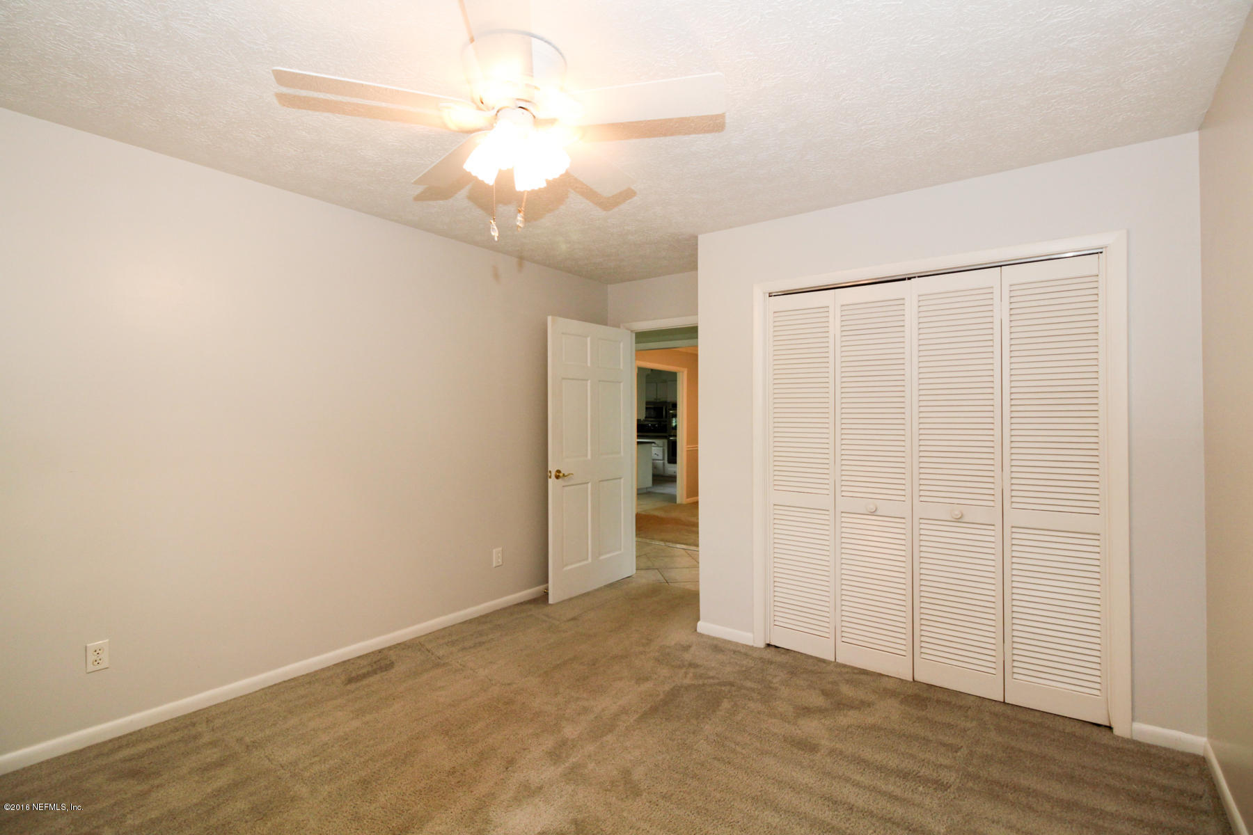 2015 Cornell Road Middleburg, FL 32068 - Photo 22 of 42 an empty room with wooden floor chandelier fan and windows