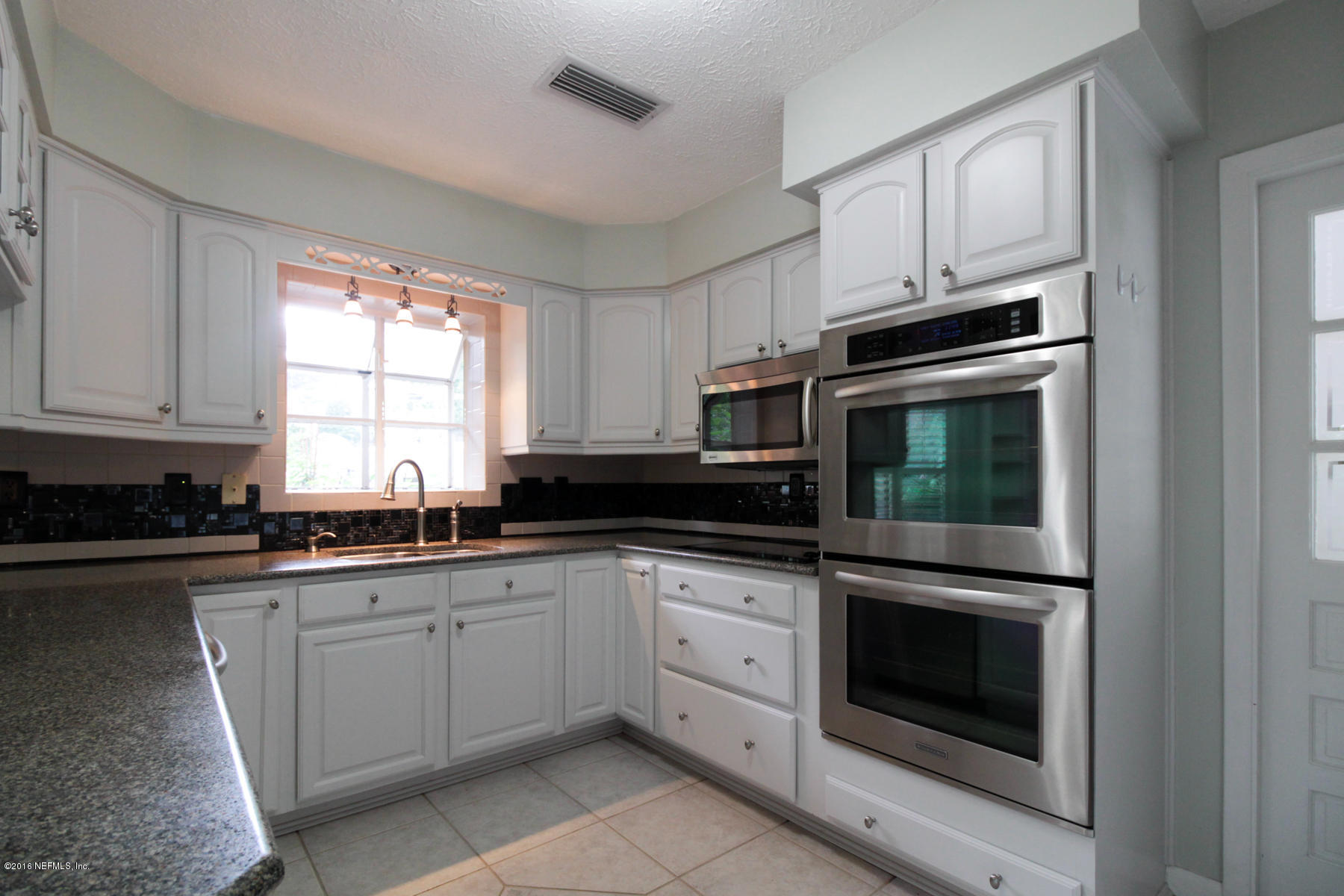 2015 Cornell Road Middleburg, FL 32068 - Photo 6 of 42 a kitchen with granite countertop white cabinets and stainless steel appliances