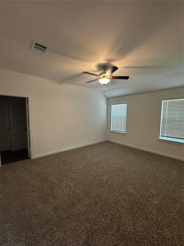 a view of an empty room with a chandelier fan