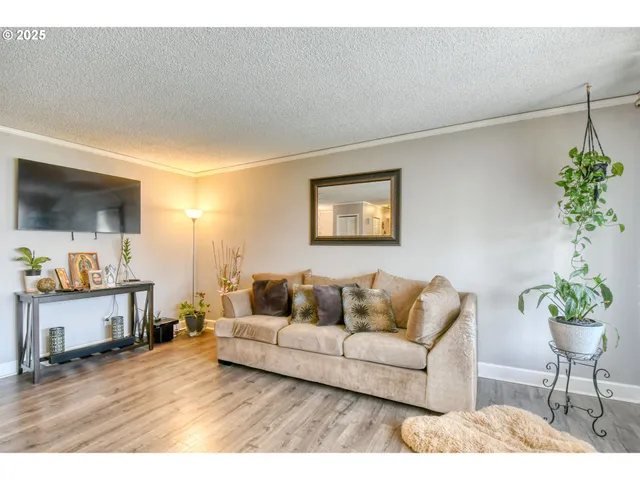 a kitchen with stainless steel appliances kitchen island granite countertop a stove a sink a refrigerator and white cabinets with wooden floor