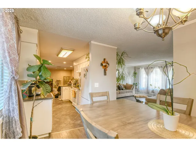 a living room with furniture a large window and a chandelier