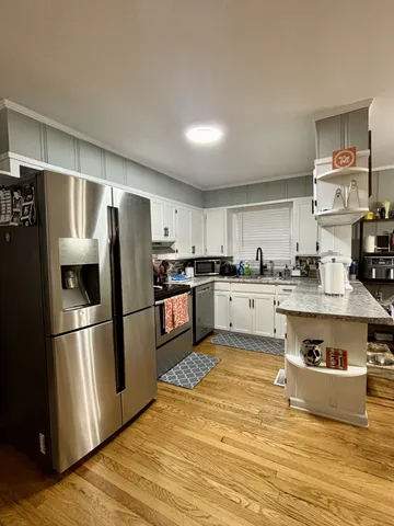a kitchen with stainless steel appliances a refrigerator sink and cabinets