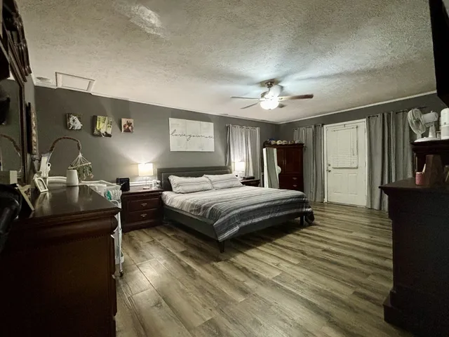 a bedroom with a bed and a flat tv screen on dresser