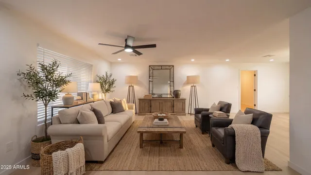 a living room with furniture a ceiling fan and a rug