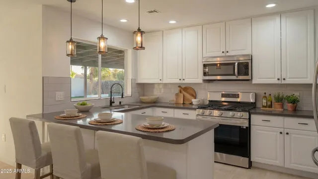 a kitchen with appliances a sink and cabinets