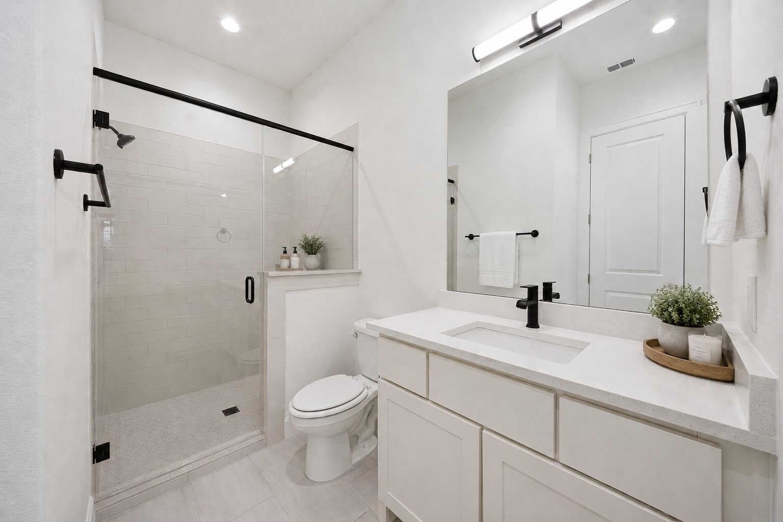 416 Venado View Court Conroe, TX 77304 - Photo 22 of 34 Beautifully appointed secondary bath featuring quartz countertops, frameless glass shower, matte black fixtures, and timeless modern finishes.