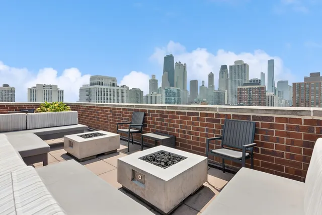 a view of a roof deck with couches and a coffee table