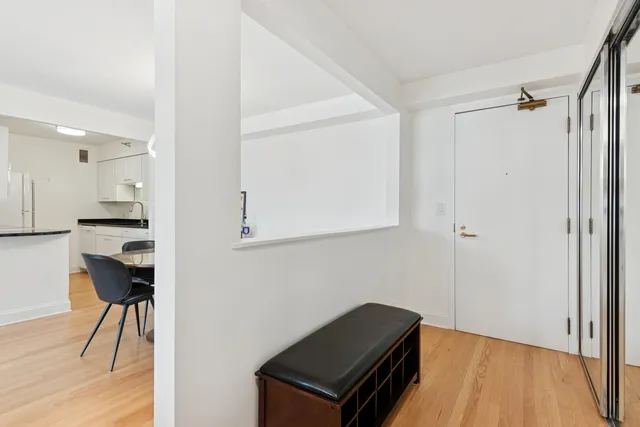 a view of a hallway with wooden floor and a cabinet