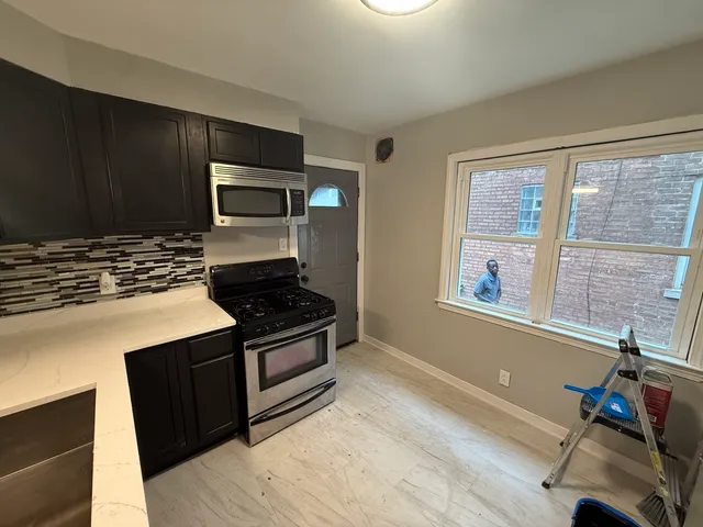 a kitchen with granite countertop a stove and a microwave