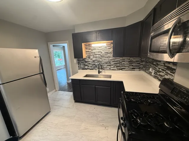 a kitchen with a refrigerator and a stove