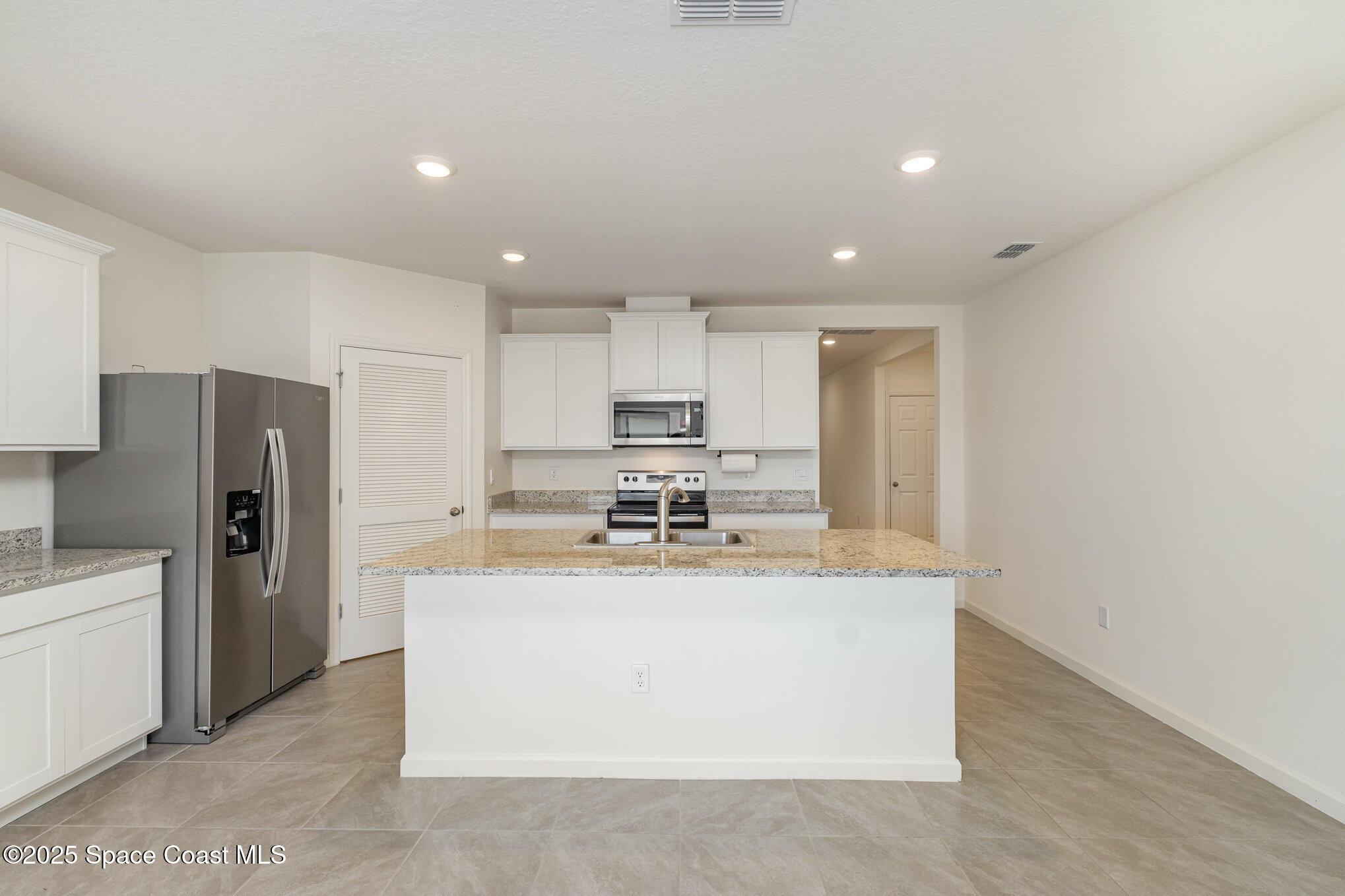 6714 Topaz Drive Grant-Valkaria, FL 32949 - Photo 4 of 33 a kitchen with stainless steel appliances granite countertop a refrigerator a sink a stove and a refrigerator with wooden floor
