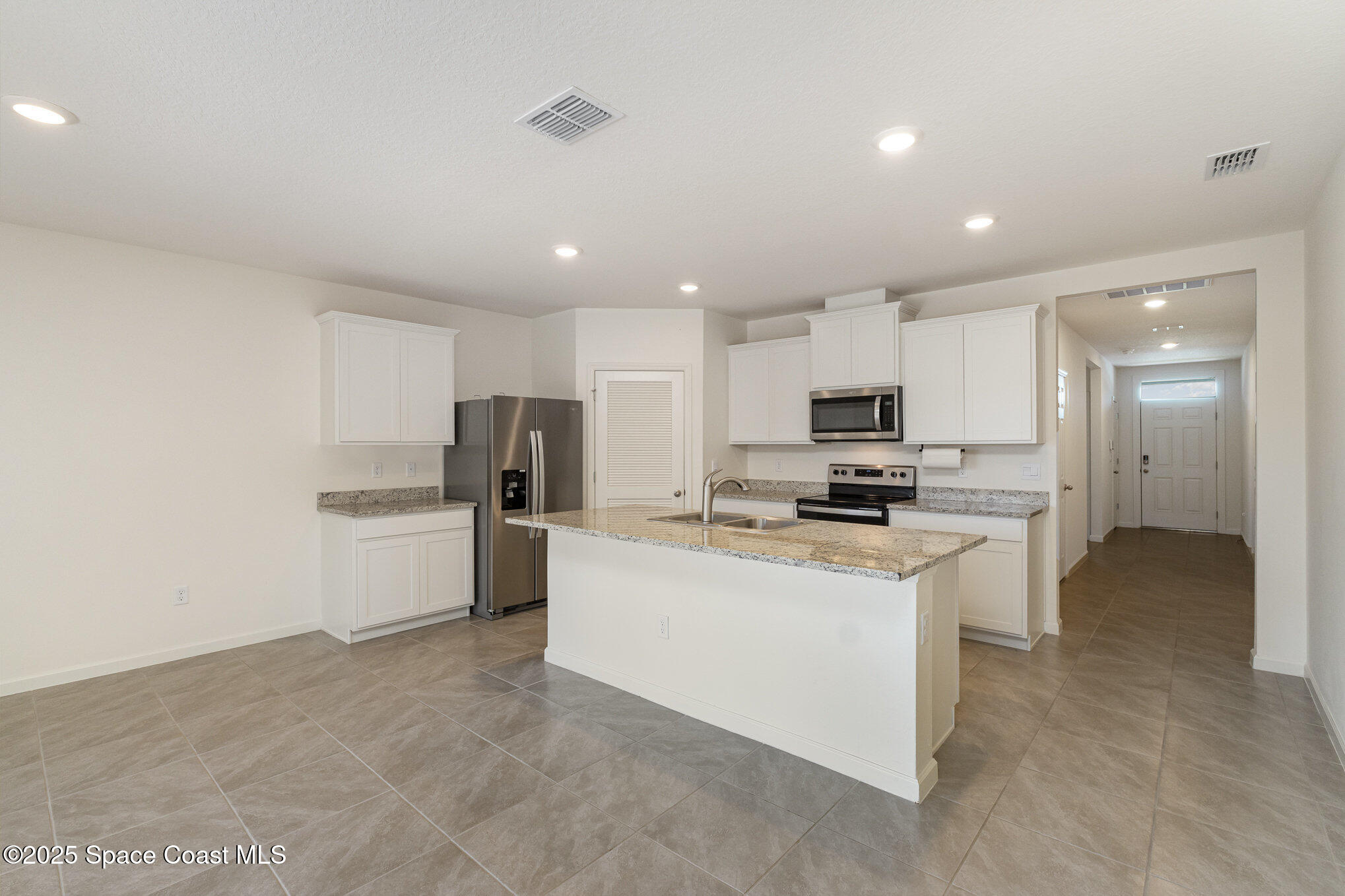 6714 Topaz Drive Grant-Valkaria, FL 32949 - Photo 5 of 33 a kitchen with stainless steel appliances granite countertop a stove and a refrigerator