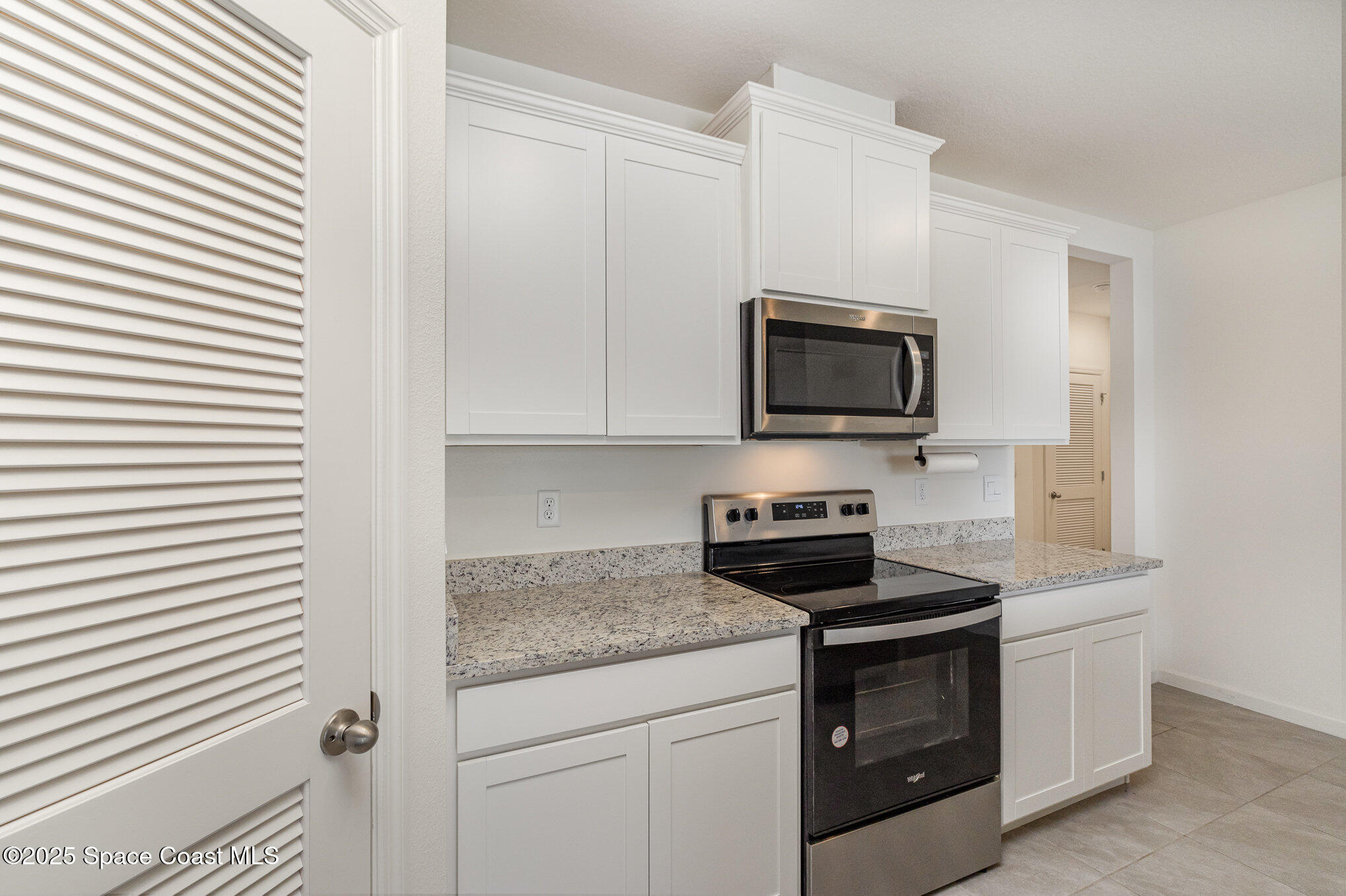 6714 Topaz Drive Grant-Valkaria, FL 32949 - Photo 10 of 33 a kitchen with stainless steel appliances granite countertop white cabinets a stove top oven