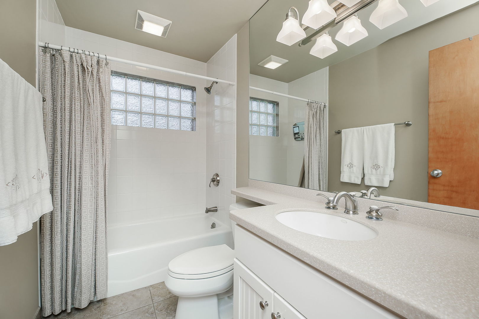 5924 Carpenter Street Downers Grove, IL 60516 - Photo 15 of 28 a bathroom with a granite countertop sink a toilet a mirror and bathtub