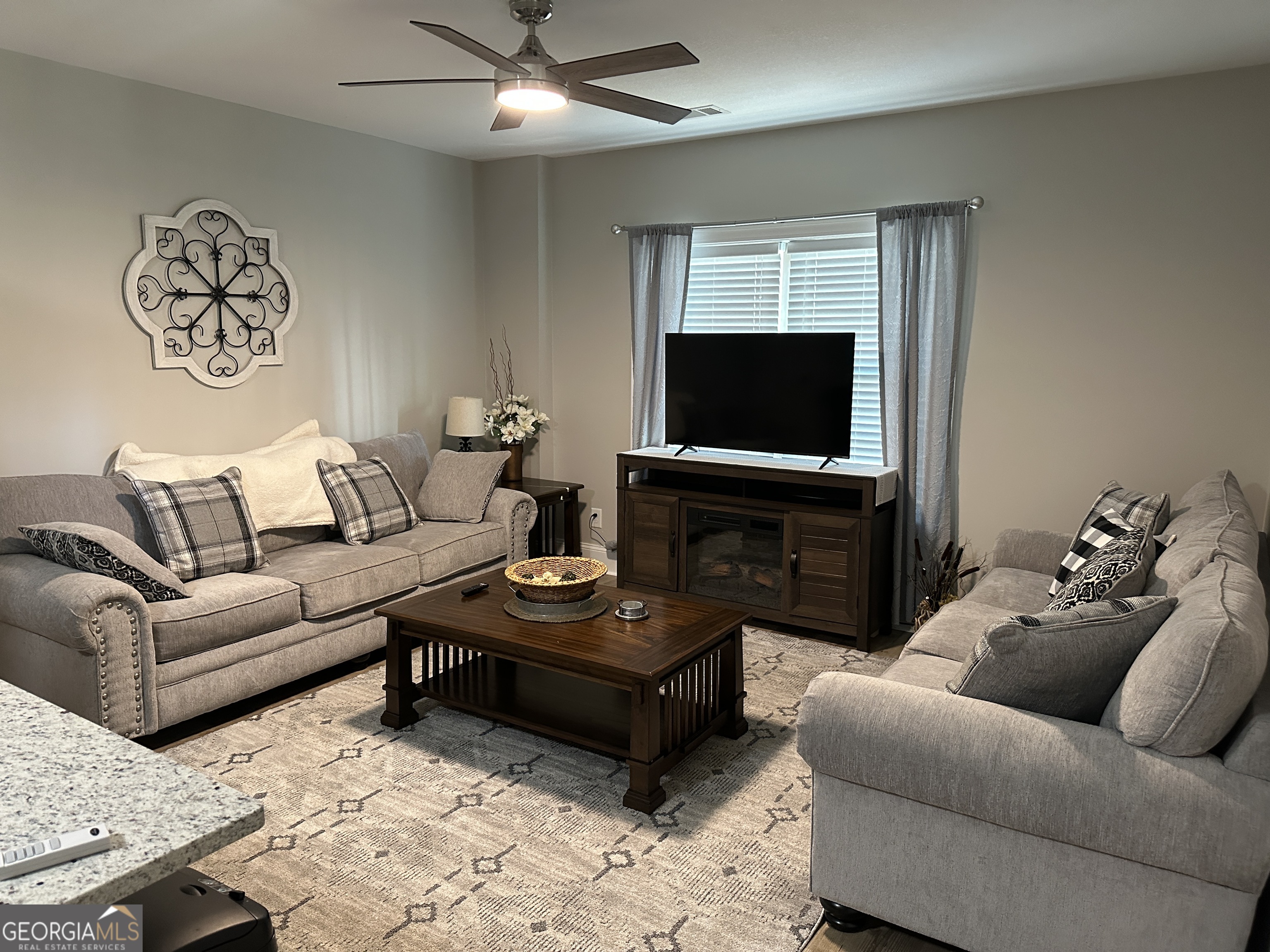 88 Old Vineyard Way Cleveland, GA 30528 - Photo 4 of 8 a living room with furniture a fireplace and a flat screen tv