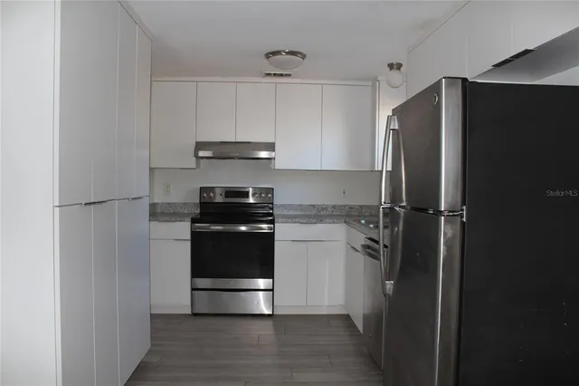 a kitchen with a refrigerator and a stove