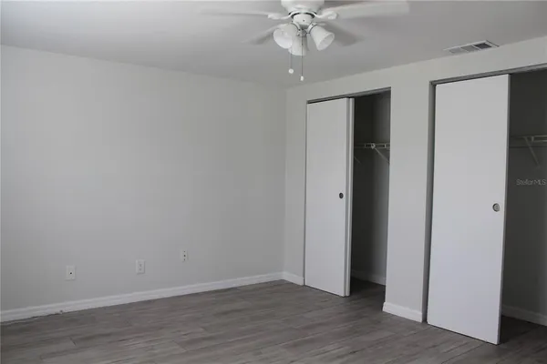 a view of an empty room with wooden floor