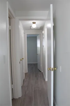 a view of a hallway with wooden floor