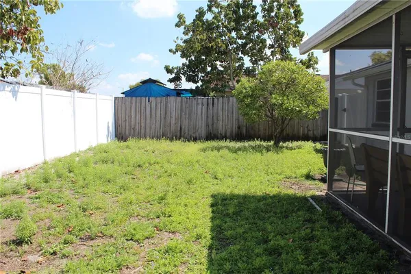 a view of backyard with small cabin and wooden fence