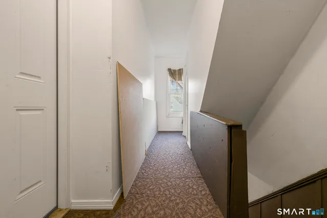 a view of a hallway with wooden floor and staircase