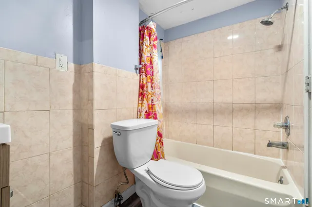 a bathroom with a toilet and a shower