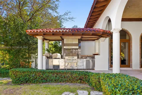 a view of a house with a small yard plants and large tree