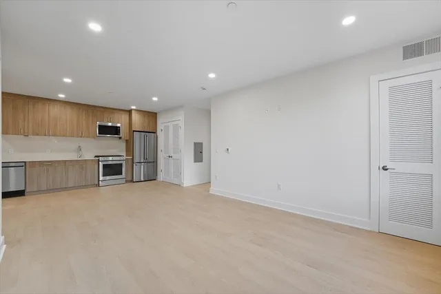 a view of an empty room with a kitchen