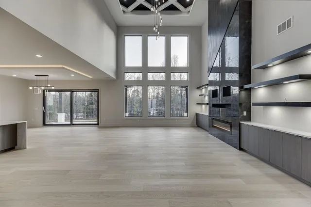 a large kitchen with stainless steel appliances a large counter top a refrigerator and a sink