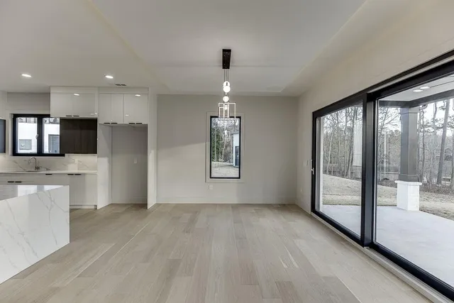 an empty room with wooden floor fireplace and windows