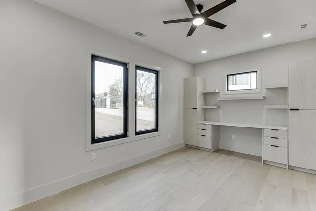 a view of an empty room with a fireplace and windows