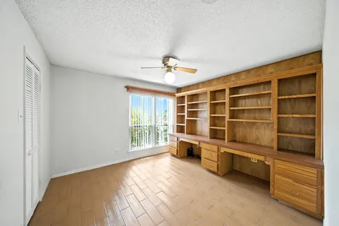 a view of an empty room with a window and a kitchen