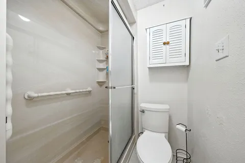 a bathroom with a toilet and a shower