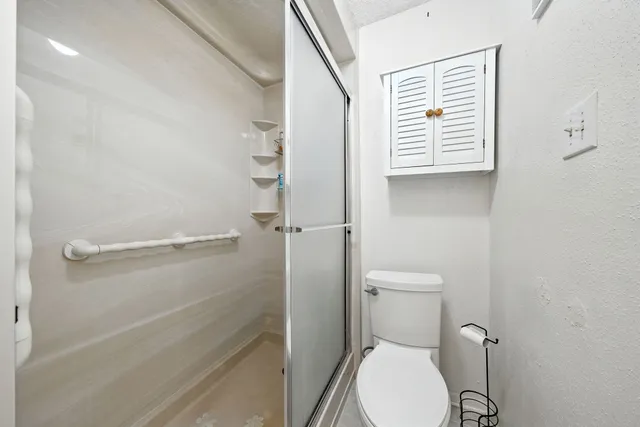 a bathroom with a toilet and a shower