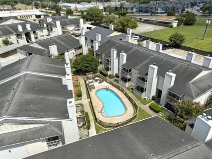 an aerial view of residential houses with outdoor space and parking