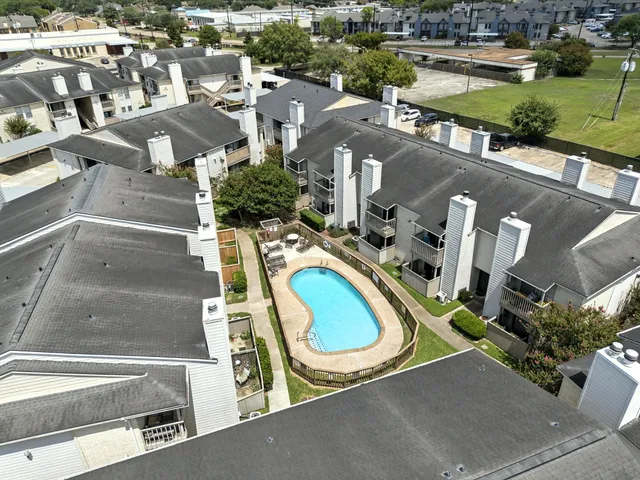 an aerial view of residential houses with outdoor space and parking