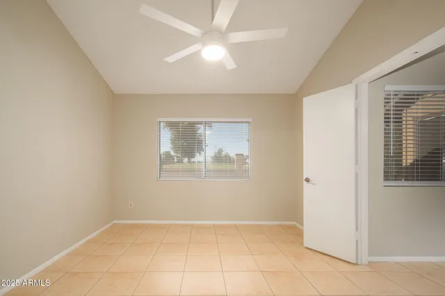 an empty room with windows and fan
