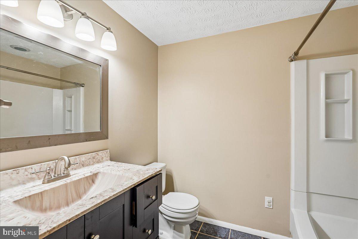 2331 Middle Creek Lane Reston, VA 20191 - Photo 40 of 78 a bathroom with a granite countertop sink a toilet and a mirror