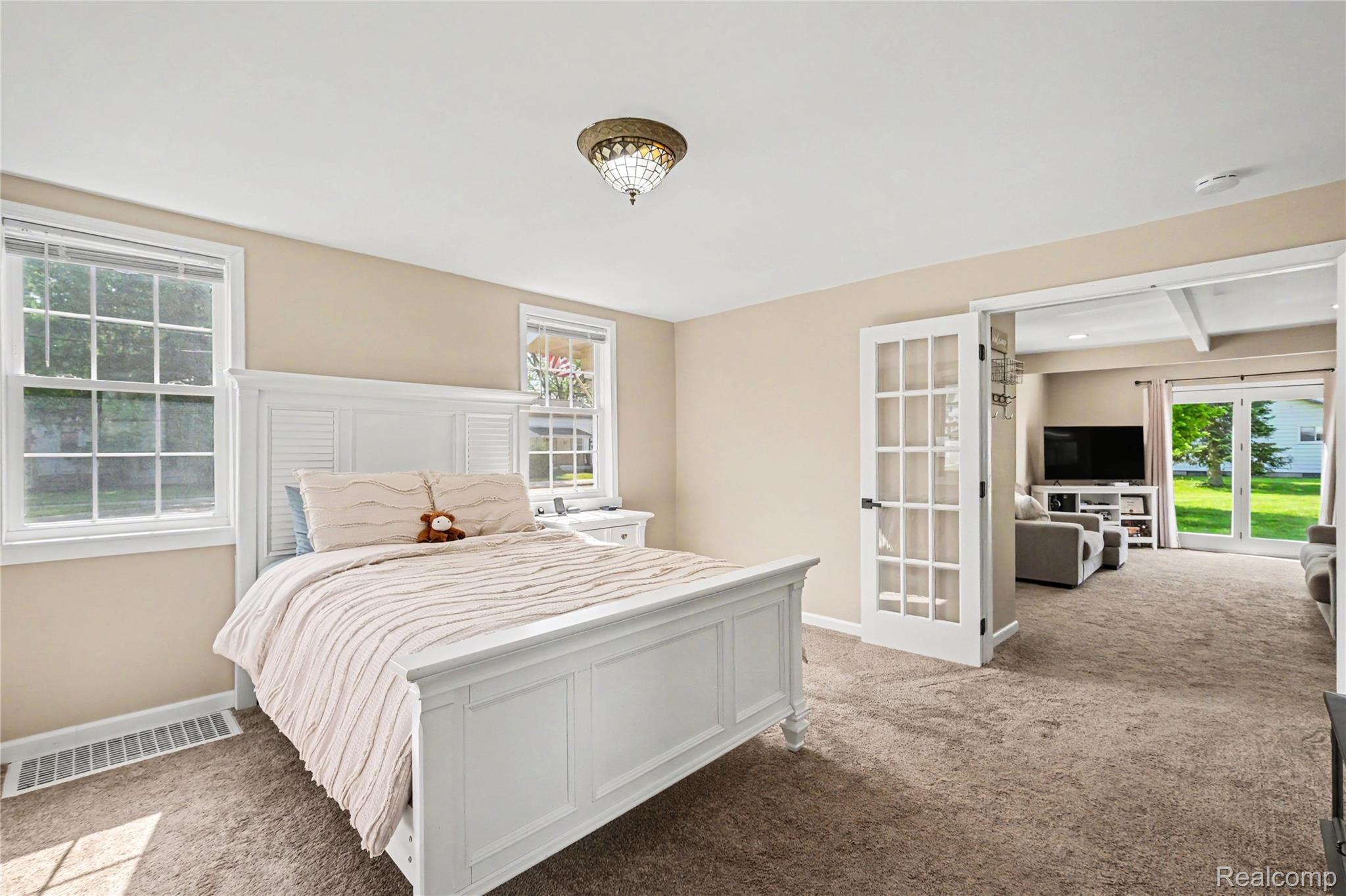 306 Mill Street Pinckney, MI 48169 - Photo 12 of 29 Enjoy the 1st floor primary bedroom with french doors leading into the main living area
