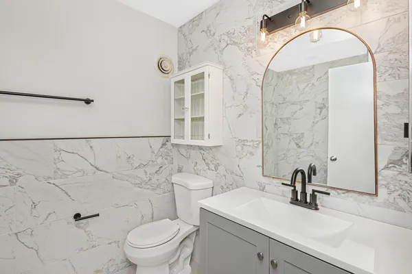 a bathroom with a sink a toilet and a mirror