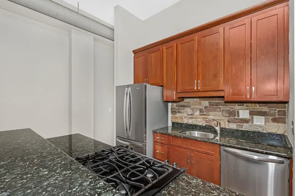 a kitchen with stainless steel appliances granite countertop a refrigerator stove and sink