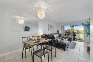 a dining room with wooden floor a chandelier a wooden table and chairs