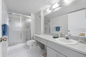 a bathroom with a sink toilet double vanity and shower