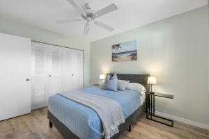 2236 North Cypress Bend Drive, Unit 311 Pompano Beach, FL 33069 - Photo 16 of 56 a bedroom with a bed and a chandelier