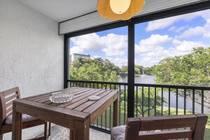 2236 North Cypress Bend Drive, Unit 311 Pompano Beach, FL 33069 - Photo 19 of 56 a view of a balcony with table and chairs