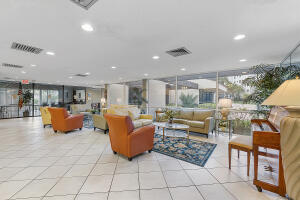 2236 North Cypress Bend Drive, Unit 311 Pompano Beach, FL 33069 - Photo 31 of 56 a living room filled with furniture and kitchen view