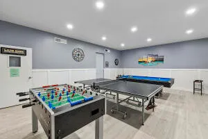 a room with table tennis pool table and arcade game machine