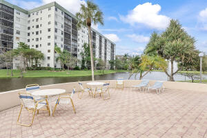 2236 North Cypress Bend Drive, Unit 311 Pompano Beach, FL 33069 - Photo 37 of 56 a view of a lake with a bench and trees around