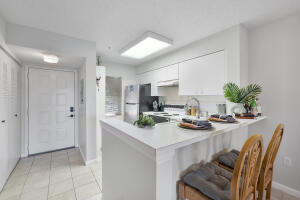 2236 North Cypress Bend Drive, Unit 311 Pompano Beach, FL 33069 - Photo 6 of 56 a kitchen with a table and chairs in it